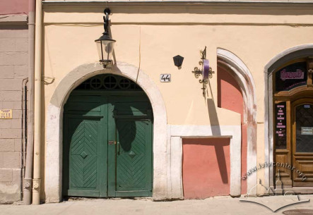 Pl. Rynok, 44. View at the main entrance. Also, a part of a preserved stone gothic arch can be seen