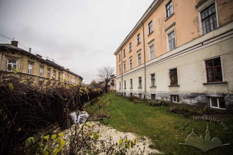 Vul. Hrushevskoho, 4. Greenery in front of the building. On the left, the housing on the opposite side of vul. Hrushevskoho