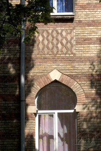 Vul. Rappaporta, 8. Pointed horseshoe arch of a 1st floor window and interfenestral brick ornaments