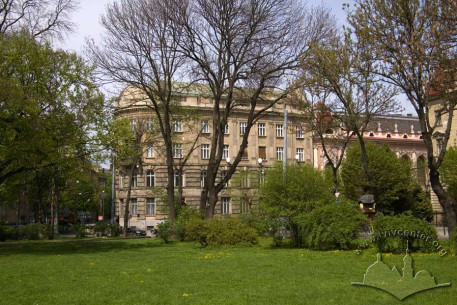 Вул. Листопадового чину, 8. Вид на південно-східний фасад будинку крізь дерева скраю парку ім. І. Франка