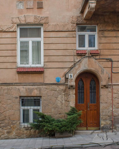 Vul. Vyshenskoho, 9. Entrance to the building with a Neogothic gable (wimperg). The first floor windows have stylized hood molds in the shape of a textured ribbon of rustication imitating natural stone.