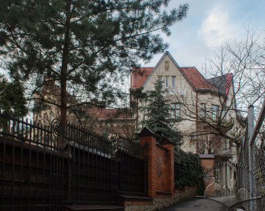 Vul. Vyshenskoho. A view of the buildings no 11 and 13 from the south. On the foreground, the fence and greenery of the villa (vul. Vyshenskoho, 12)